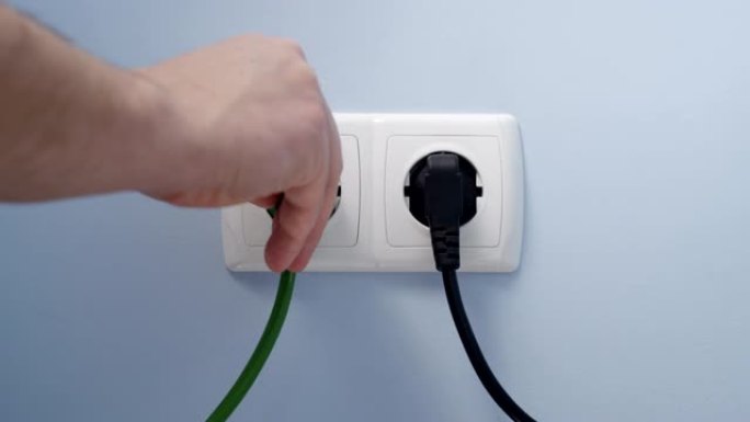将绿色电源插头插入电源插座，作为可再生可持续替代能源发展的概念