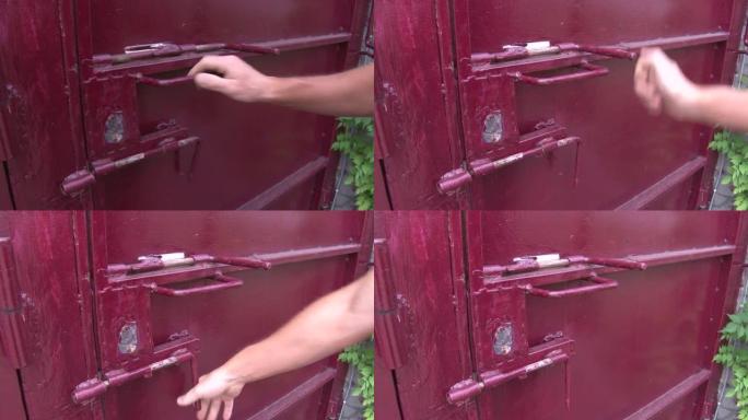 那人的手在门上放了一把挂锁。特写