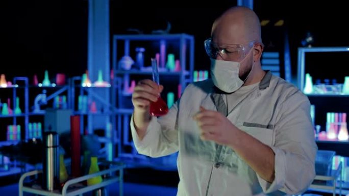 科学家化学家看着容器中的液体。穿着白大褂和眼镜的人正在研究烧瓶中的成分。化学实验室。