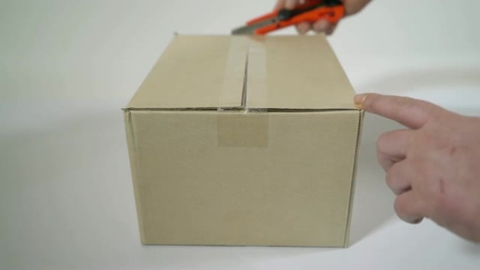 男子打开装有罐头食品的纸板箱