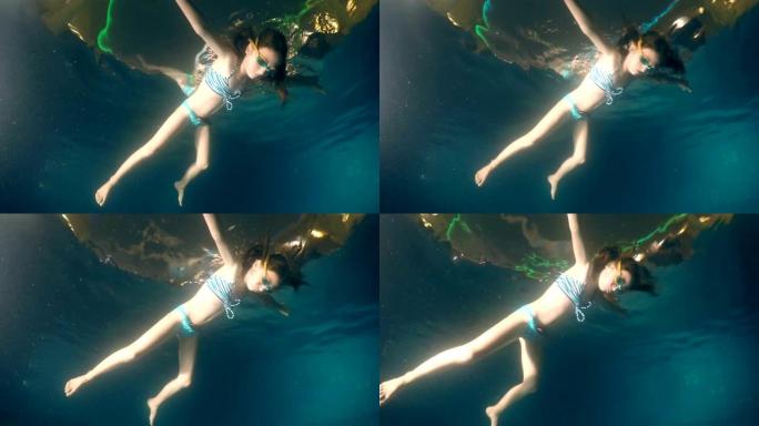 淹死的女孩晚上躺在游泳池面上，水下景观