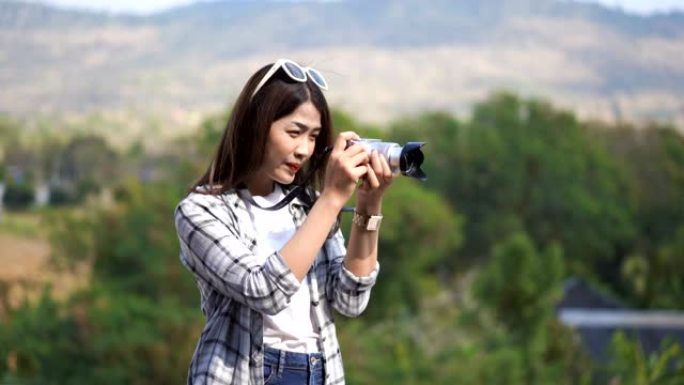 旅游妇女在大自然中用相机拍照
