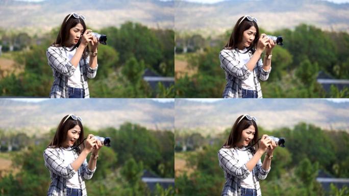 旅游妇女在大自然中用相机拍照