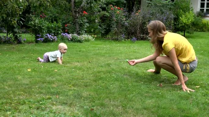 女婴手里拿着奶嘴在草地上给妈妈鸣叫。4K