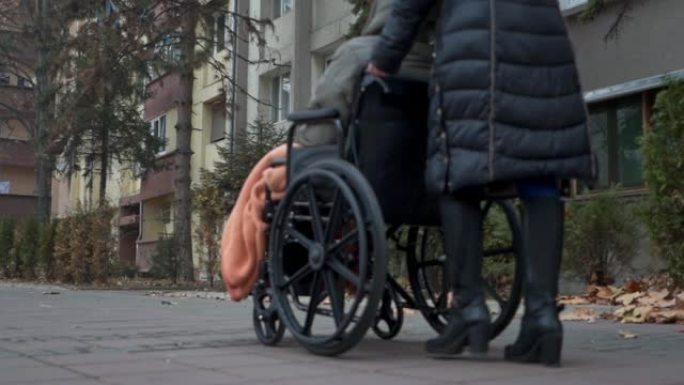 社工运送一名坐轮椅的老妇