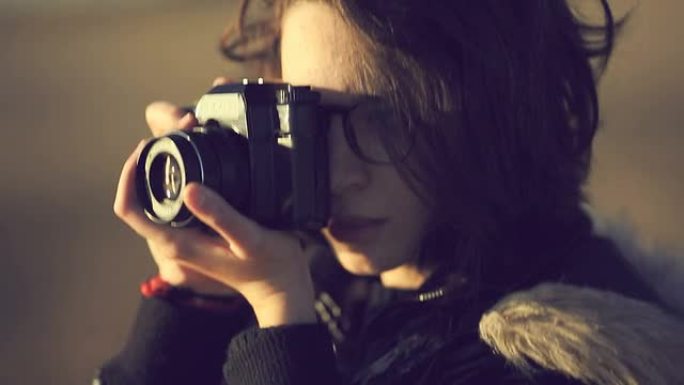 十几岁的女孩用一台旧的电影相机拍照
