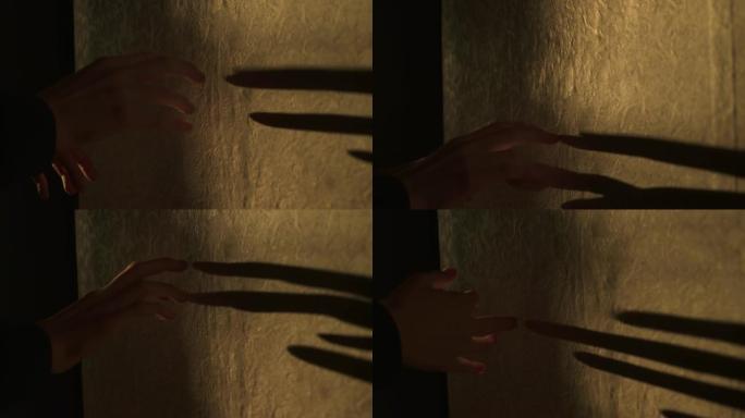 皮影戏。手臂的黑色阴影，在旧墙上显示橙色光的不同人物