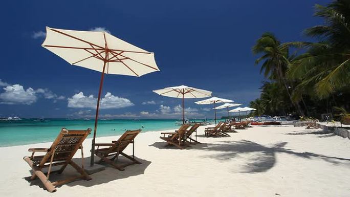 白沙海岸线上的太阳伞和沙滩椅