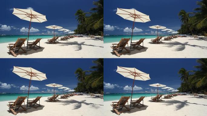 白沙海岸线上的太阳伞和沙滩椅