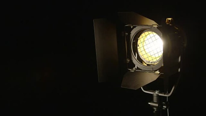 缓慢调光视频工作室菲涅耳镜头在黑色背景上的聚光灯