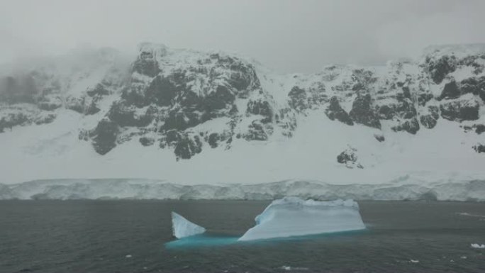 南极天堂湾丹科海岸冰川冰山上空的暴风雪