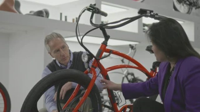 女售货员帮助一个成熟的男人买电动自行车