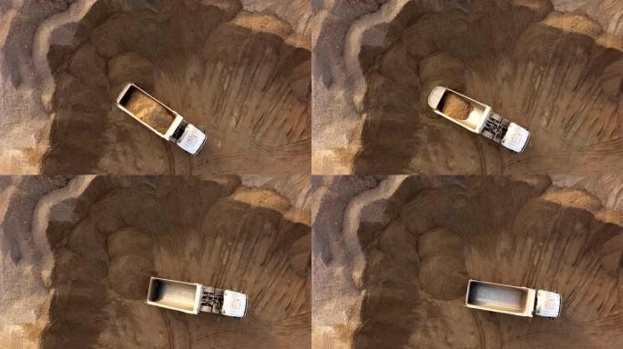 露天采石场自卸车卸砂的俯视图。