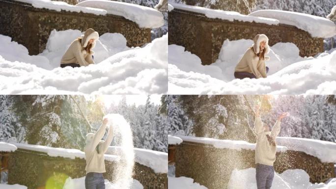 穿着针织毛衣和皮草帽子的快乐女人享受着一个阳光明媚的寒冷早晨，扔雪，在闪闪发光的雪花中旋转。