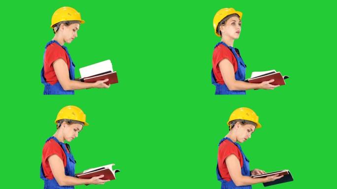 女建筑工人戴安全帽和工作服检查绿色屏幕上的名单，色度钥匙