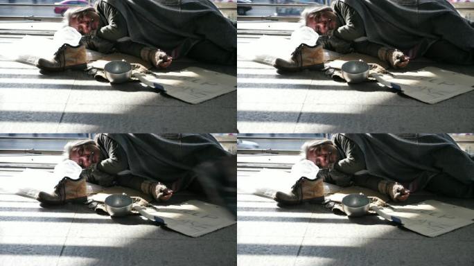 无家可归的老人穿着脏衣服在街上睡觉并寻求帮助