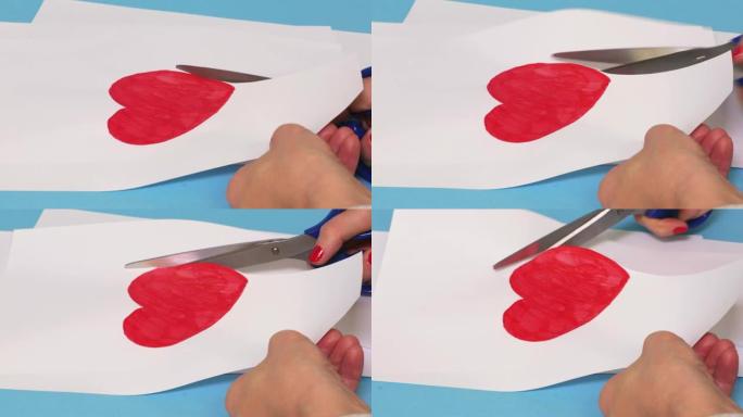 女人在白纸上剪出红色的心形
