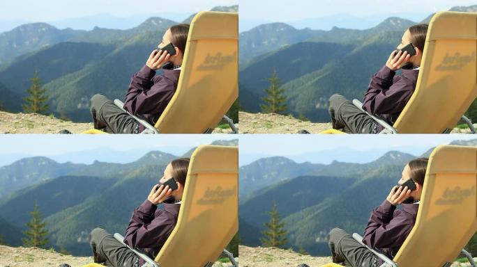 迷人的女人在山上用手机聊天