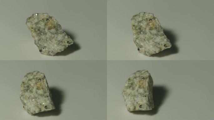 白色背景旋转的单氮花岗岩矿物样品
