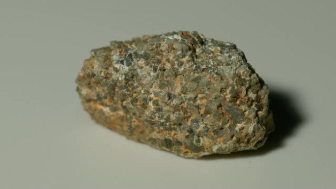 白色背景旋转的砾岩矿物样品