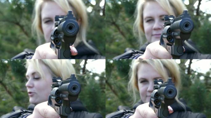 带枪的女孩带领目标。女人射击气动手枪。女性手中的气动左轮手枪。美甲特写。