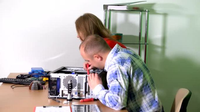 技术员男子和同事妇女在维修办公室升级计算机组件