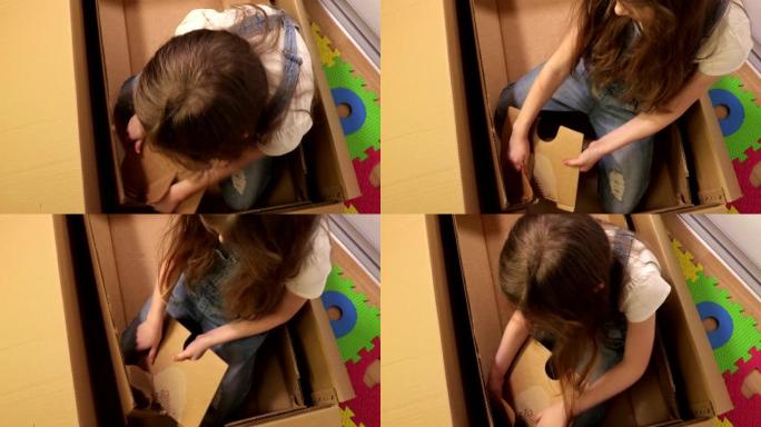 小女孩试图改善她的纸板箱