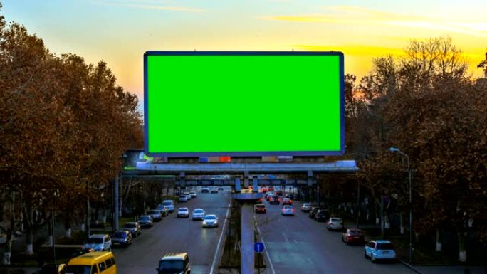 日落时快速行驶的汽车背景上带有绿色色度键的广告牌。