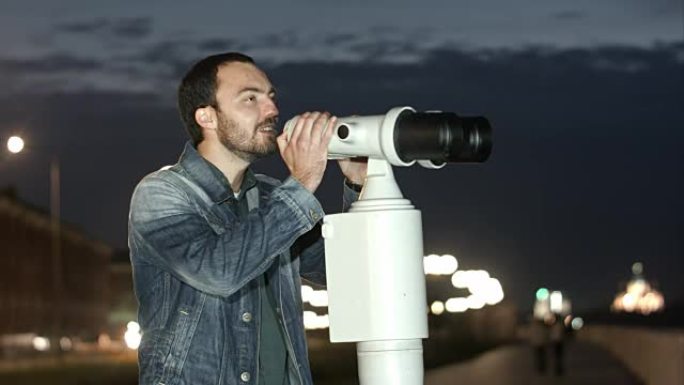 男子使用投币式望远镜欣赏城市美景