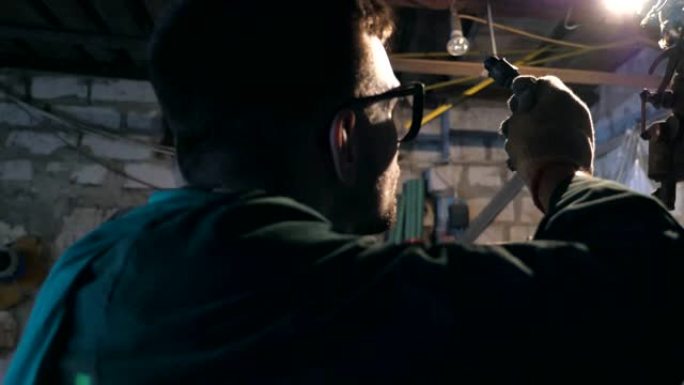 戴眼镜的男机械师在维修店仔细检查车辆细节。在车库或车间工作的修理工简介。侧视图慢动作特写