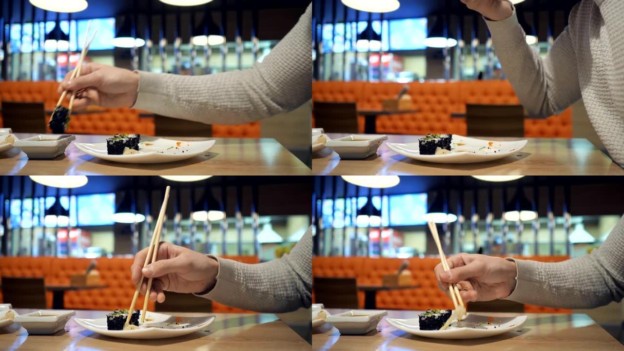 年轻夫妇用筷子从日本餐馆的盘子里拿寿司。