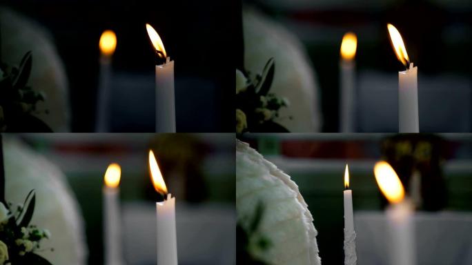 新郎在教堂里拿着蜡烛。基督教婚礼。相机从一根蜡烛平滑地聚焦到另一根蜡烛