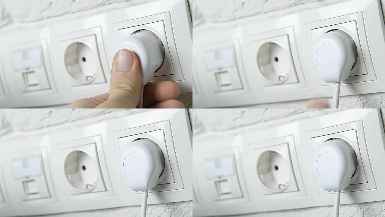 用手将电气插头插入墙壁插座。
