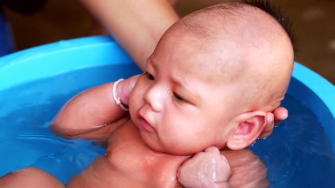 可爱的亚洲小宝宝在户外洗澡