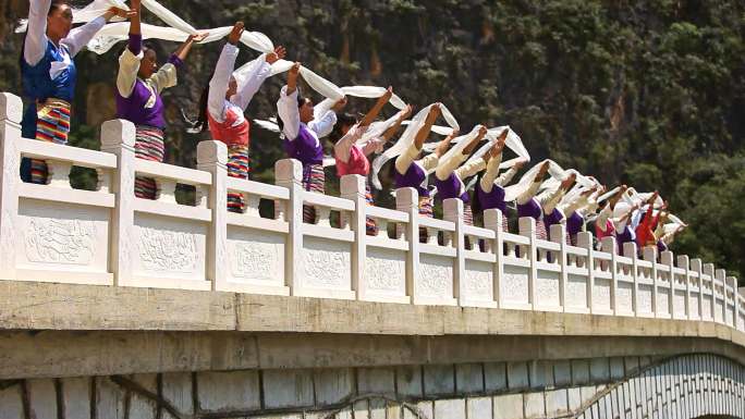 藏族女子在桥上迎风持哈达