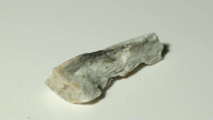 白色背景旋转的硅灰石矿物样品