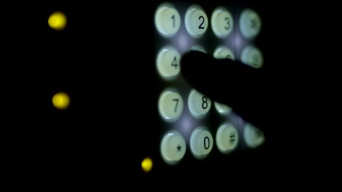 手指在带有照明按钮的键盘上输入组合代码，设置红色镜头上的安全系统