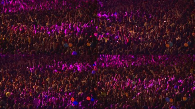 在一场摇滚音乐会上，一大群歌迷挥舞着双手鼓掌