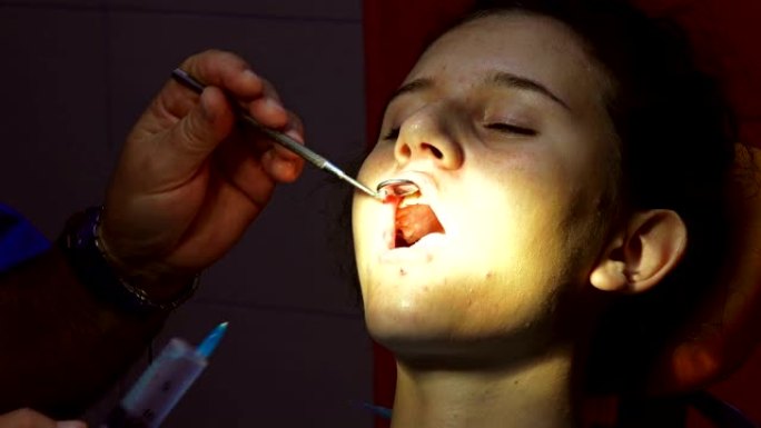 牙科医生用注射器针在口腔手术前消毒牙齿通道