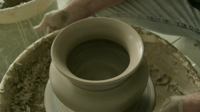 陶工用泥或陶土完成一个新瓷瓶的口部造型