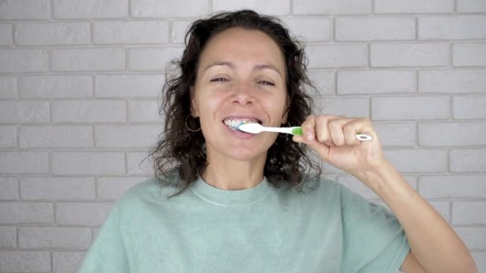 女人刷牙。