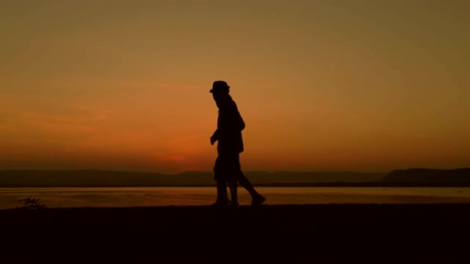 老人的剪影使用工作人员在日落时与女儿一起散步，概念是受伤后的康复，慢动作