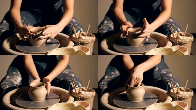 女人女孩她的手给壁壶配音，用粘土雕刻成圆圈。