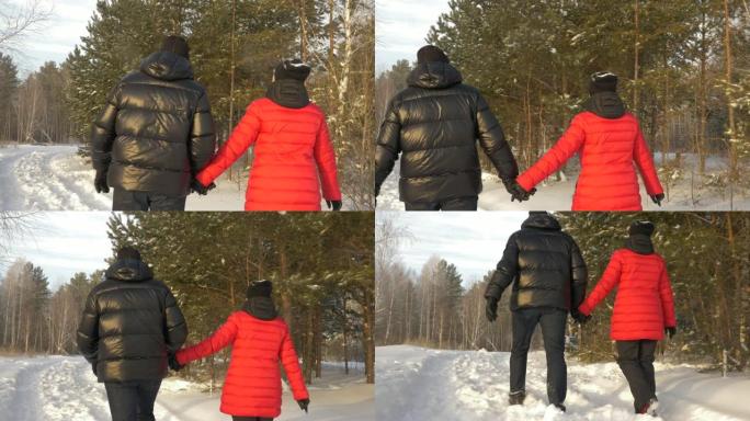 幸福夫妻男女手牵着手走在白雪皑皑的冬季森林