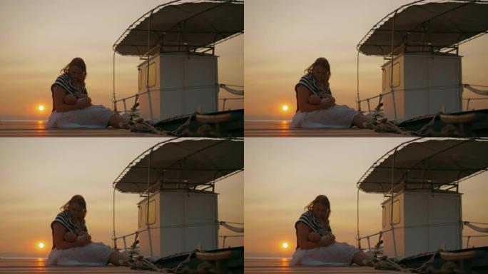 母亲在日落的码头上哺乳婴儿