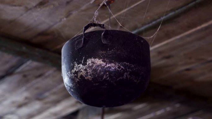 悬挂在木板上的网中的旧锅