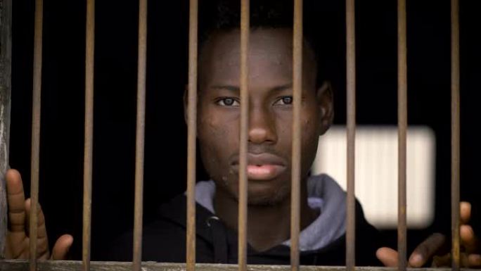 年轻的非洲移民在监狱里。非法移民，非洲，监狱