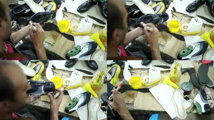 男人在工厂的鞋子上涂胶