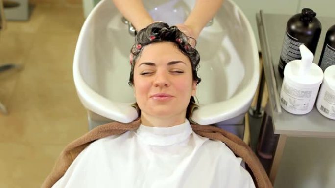 美发师在美容院理发前洗一个年轻女孩的头发。