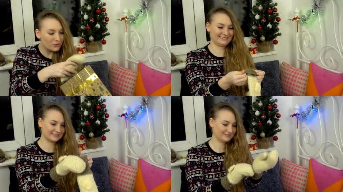 年轻漂亮的女孩收到圣诞节礼物并感到高兴